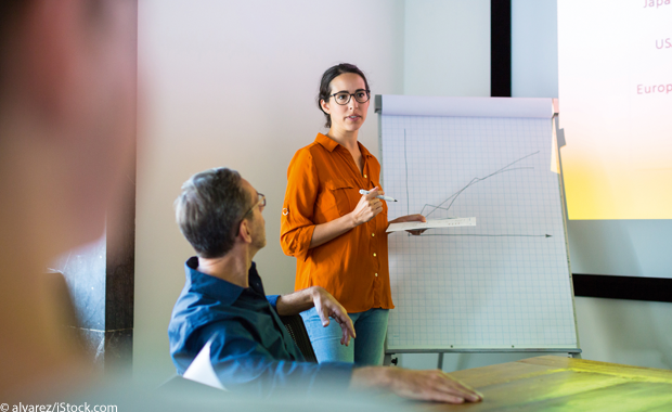 Frau vor einer Flipchart hält Präsentation