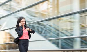 Junge Frau schaut auf die Uhr