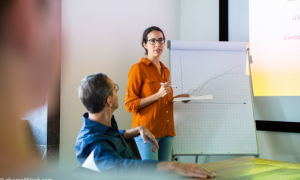 Frau vor einer Flipchart hält Präsentation