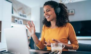 Frau mit Headset vor dem Laptop