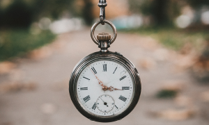 pocket watch hanging in the air with path in the background