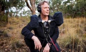 Andrew Skeoch crouched down next to his equipment in the field