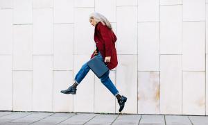 Older professional woman jumping in the air