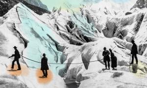 A vintage shot of early mountain climbers helping each other cross a crevasse