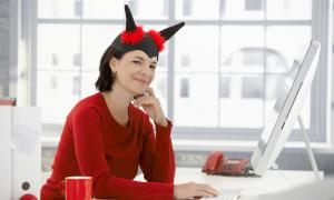 woman with fake devil horns sitting behind a desk at work