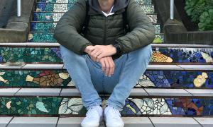 Pius Binder sitting on a set of colorful steps outdoors