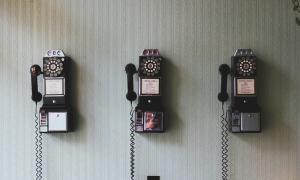 several pay telephones hanging on a wall