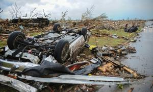 overturned cars and downed trees after a storm
