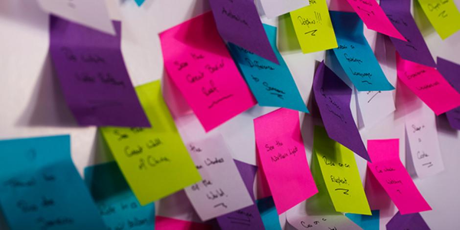 Wand mit bunten Post-Its (Tipp zum Business-Englisch-Lernen: Notieren Sie wichtige Wörter auf Post-its)