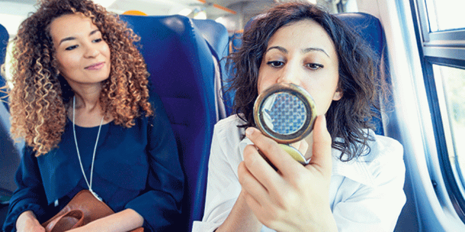 Frauen schminken sich auf einer Zugfahrt