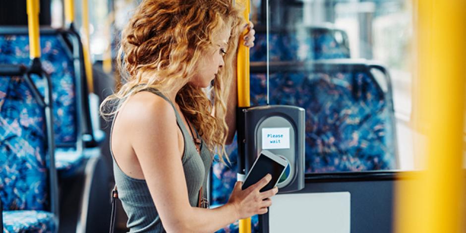 Frau zahlt im Bus kontaktlos