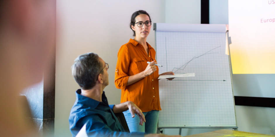 Frau vor einer Flipchart hält Präsentation