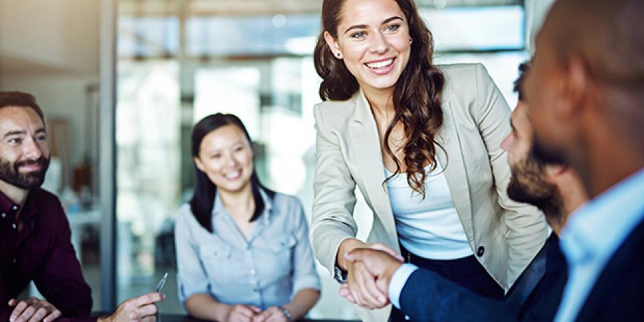 Two people shake hands in a meeting situation