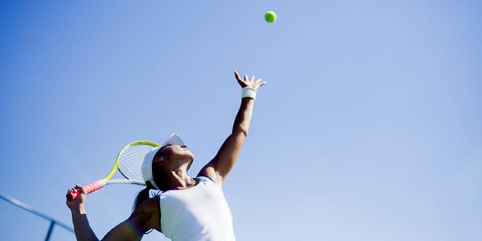 Frau beim Tennis-Aufschlag