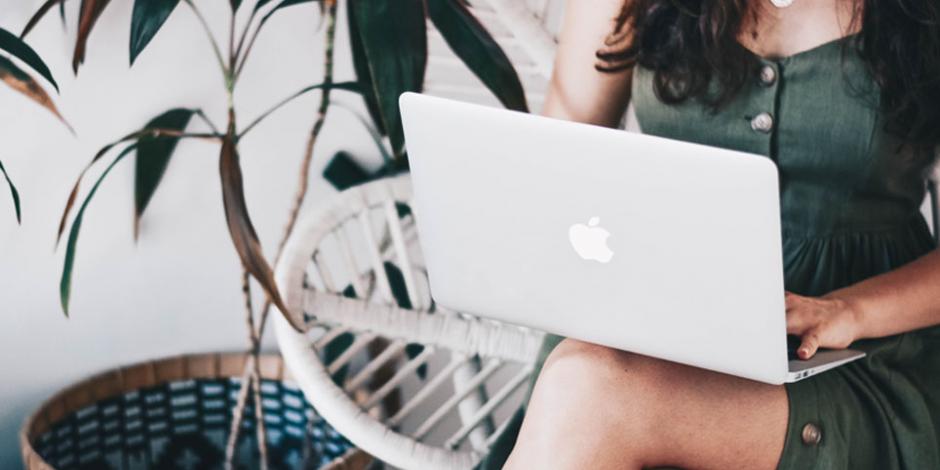 A woman working remotely with a laptop on her lap