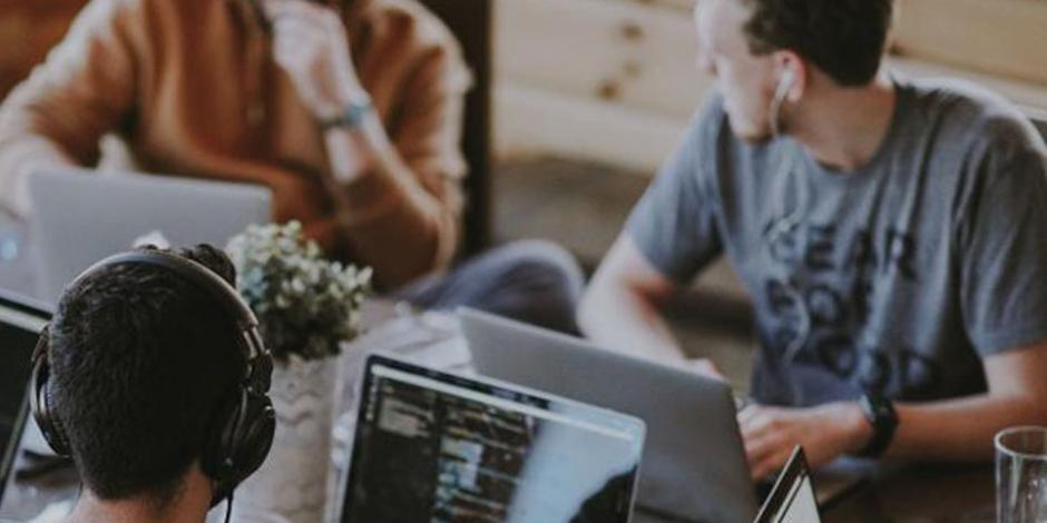 People working together at a table with their laptops