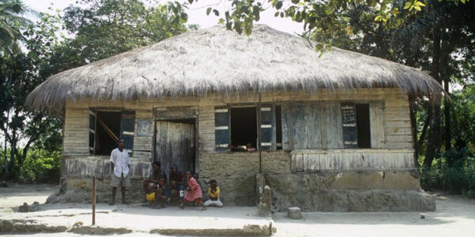 a simple house with a family sitting close together in front of it