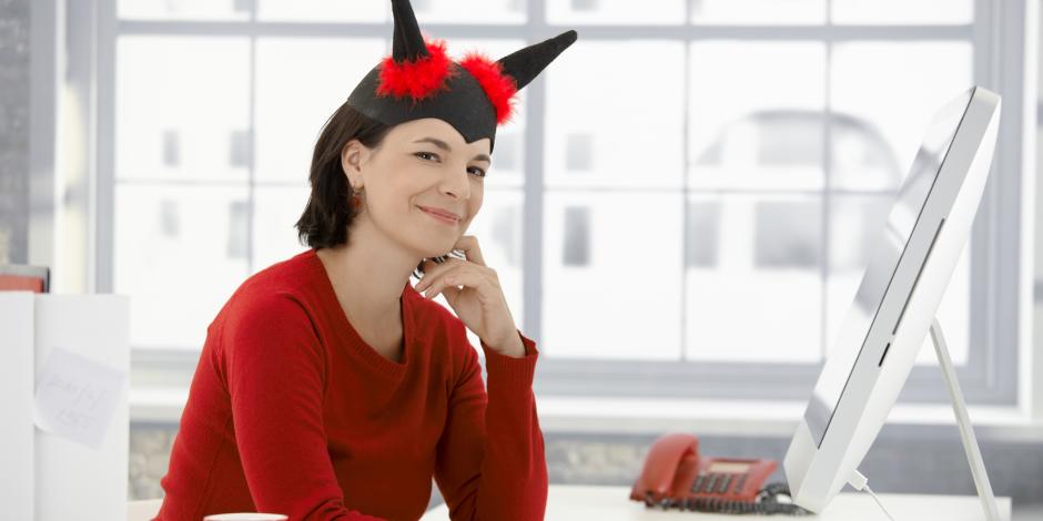 woman with fake devil horns sitting behind a desk at work