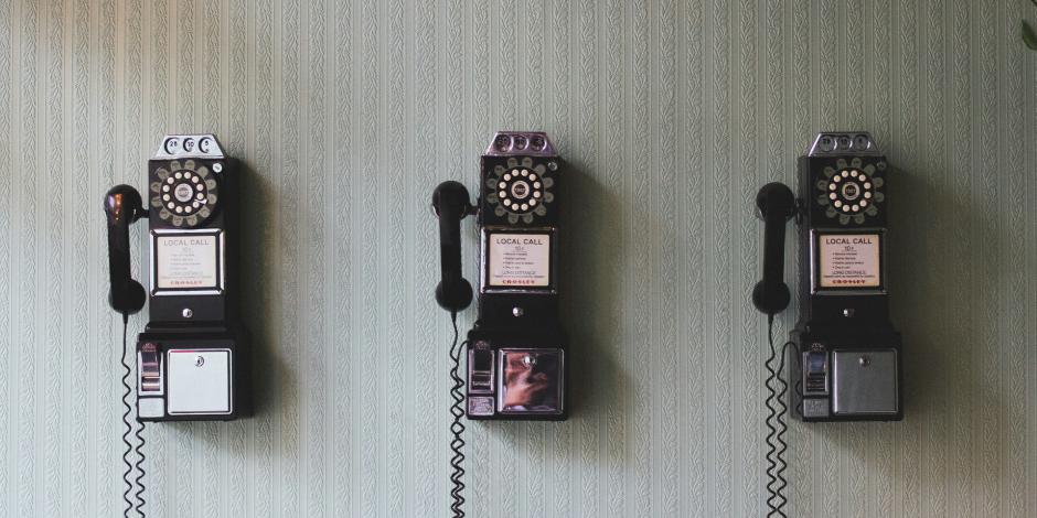 several pay telephones hanging on a wall
