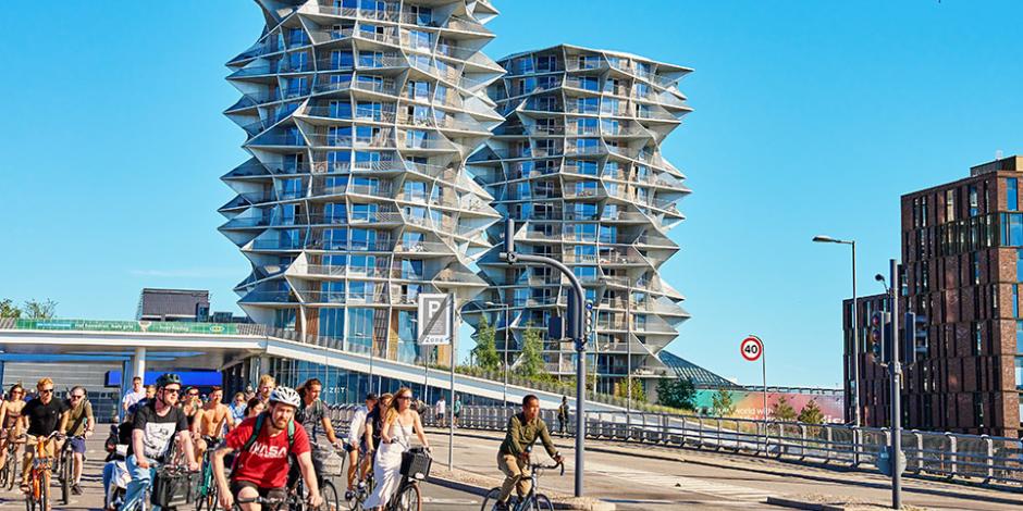 People riding bicycles on busy city street in Copenhagen, Denmark. 