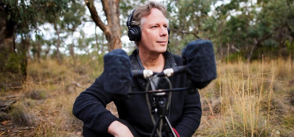 Andrew Skeoch crouched down next to his equipment in the field