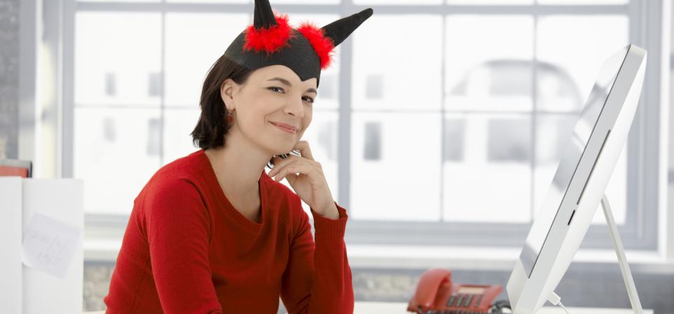 woman with fake devil horns sitting behind a desk at work