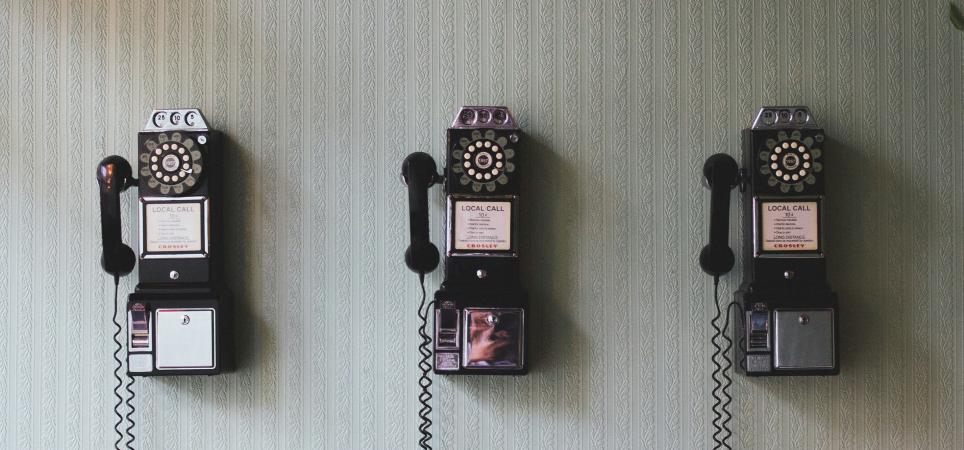several pay telephones hanging on a wall