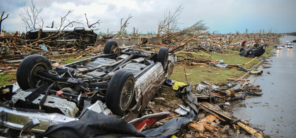 overturned cars and downed trees after a storm