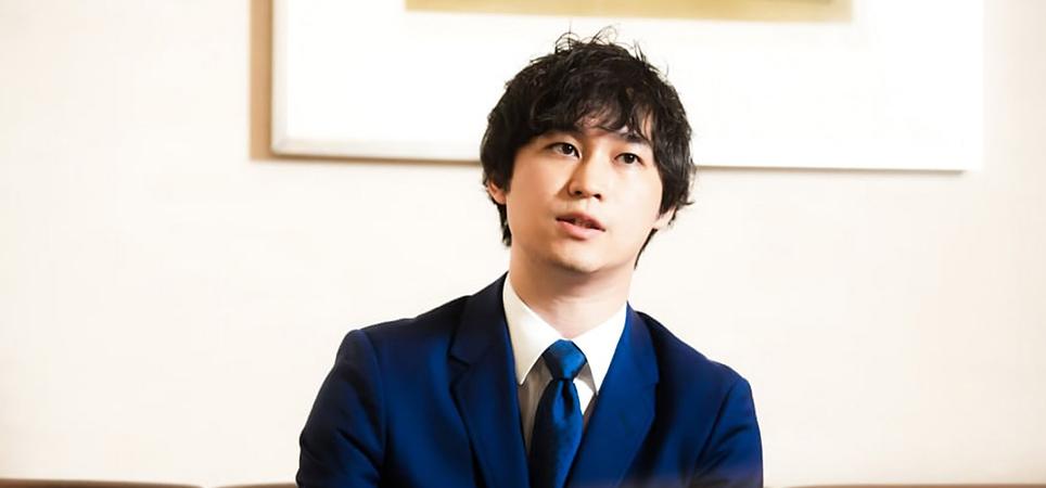 Shunsaku Sagami speaks while sitting on a couch