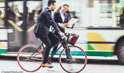 Strassenszene mit Geschäftsleuten. Junger Geschäftsmann mit Fahrrad.