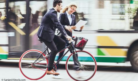 Strassenszene mit Geschäftsleuten. Junger Geschäftsmann mit Fahrrad.