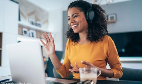 Frau mit Headset vor dem Laptop