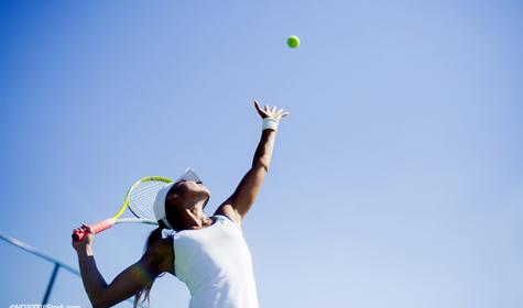 Frau beim Tennis-Aufschlag