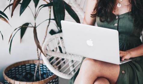 A woman working remotely with a laptop on her lap