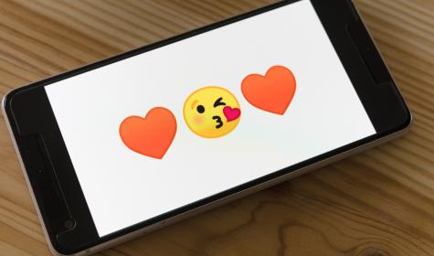 Kiss and heart emojis on a mobile phone screen
