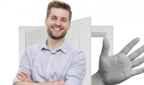 A man standing in front of an open door with a hand coming out of it.