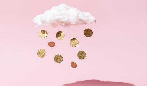 coins falling out of a cloud against a pink background