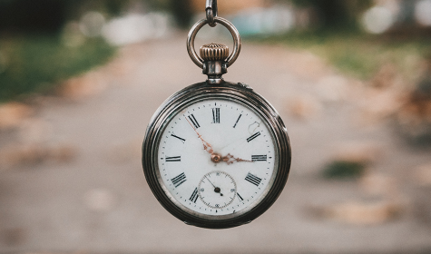 pocket watch hanging in the air with path in the background