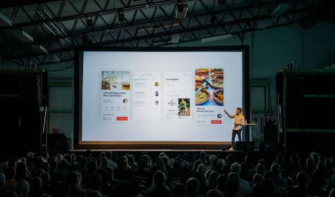 man presenting in front of a large crowd