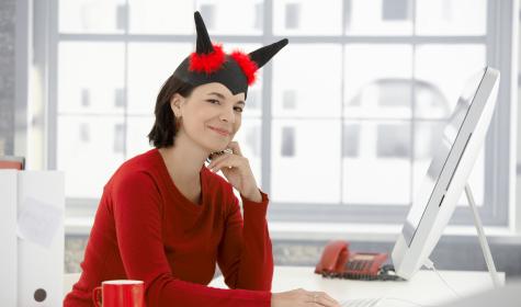 woman with fake devil horns sitting behind a desk at work