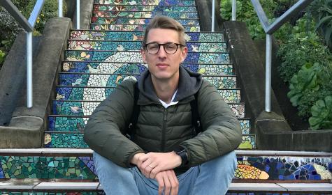 Pius Binder sitting on a set of colorful steps outdoors