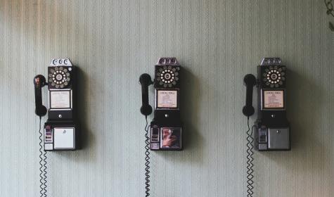 several pay telephones hanging on a wall
