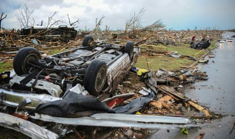 overturned cars and downed trees after a storm